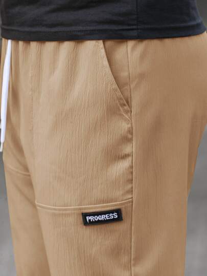 Manfinity Homme سروال رجالي عريض القصة واسع الساقين مع لصقات أحرف وخصر برباط