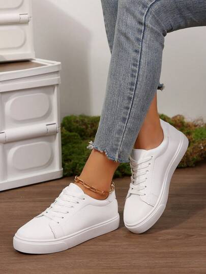 زوج من أحذية المرأة البيضاء الجديدة الصيفية المتعددة الاستخدامات مقاس كبير، أحذية رياضية كاجوال منبسطة، سطح من الجلد لأحذية بيضاء