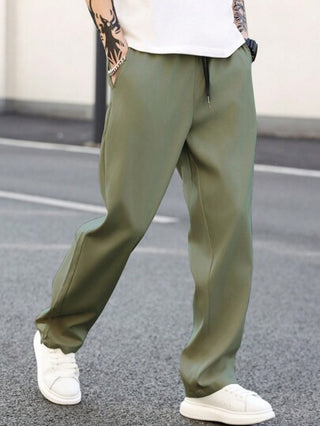 Manfinity Homme بنطلون رجالي قطعة واحدة لون سادة بخصر مرن وجيوب جانبية بقصة واسعة للساقين