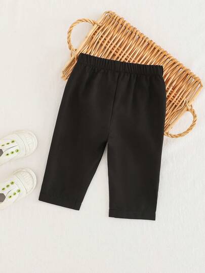 SHEIN Playful Pals بنطلون أسود للأطفال الرضع، متعدد الاستخدامات ومناسب للأطفال لارتدائه في أي مناسبة، ويمكن ارتداؤه في أي فصل. الوسط الأمامي به أزرار زخرفية لإضافة مزيد من تفاصيل التصميم إلى الملابس