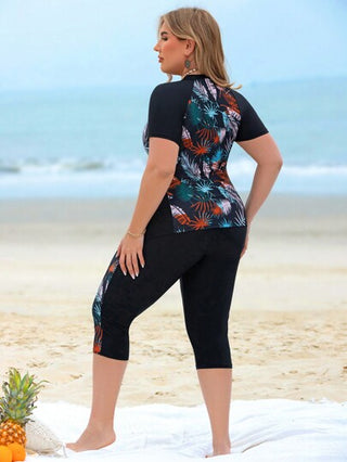 Swim Lushoire مجموعة ملابس سباحة غير رسمية لحمامات السباحة وشواطئ المنتجعات للمرأة ذات المقاسات الكبيرة، مكونة من توب كروب بدون أكمام مطبوع بتصميم رقعي مطبوع عشوائي بأوراق نباتية ممزوجة باللون الأسود وشورت سباحة طويل