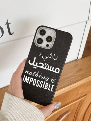 هاتف محمول مطبوع عليه نص "لا شئ مستحيل" باللغة الإنجليزية والعربية، تصميم أنيق بغلاف أسود ذو ملمس جلدي فاخر، يوفر حماية شاملة للهاتف. متوافق مع أجهزة آيفون وجالاكسي، يناسب آيفون 13