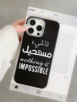 هاتف محمول مطبوع عليه نص "لا شئ مستحيل" باللغة الإنجليزية والعربية، تصميم أنيق بغلاف أسود ذو ملمس جلدي فاخر، يوفر حماية شاملة للهاتف. متوافق مع أجهزة آيفون وجالاكسي، يناسب آيفون 13