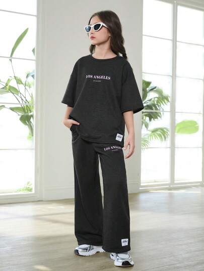 SHEIN مجموعة ملابس مريحة لصبايا تتراوح أعمارهن بين ال8-12سنة، مكونة من سويت شيرت طاقم كرو مطبوع بالموسيقى الجرانج وسروال رياضي مطبوع، بتصميم متساهل، مناسبة للربيع والخريف