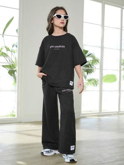 SHEIN مجموعة ملابس مريحة لصبايا تتراوح أعمارهن بين ال8-12سنة، مكونة من سويت شيرت طاقم كرو مطبوع بالموسيقى الجرانج وسروال رياضي مطبوع، بتصميم متساهل، مناسبة للربيع والخريف