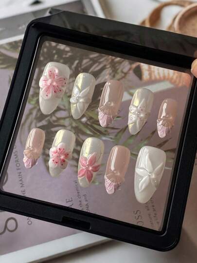 10 قطعة من الأظافر الجميلة المصنوعة يدويا بنمط فرنسي، بشكل لوز، ذات لون أبيض قاعدي، مزينة بأزهار وصدف مشكلة بالضغط باليد، يدوية خالصة، قابلة للإزالة وإعادة الاستخدام، مناسبة للفتيات والنساء في الاستخدام اليومي والأعياد والحفلات والزفاف، مع صمغ جيلي...