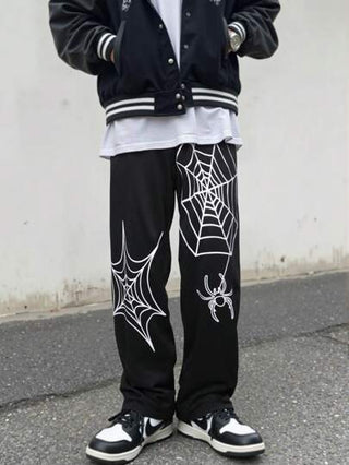 Yemwry بنطلون كاجوال رجالي أسود بخصر مرن. يتميز البنطلون بتصميم أنماط عنكبوت وشبكة عنكبوت بيضاء، بتصميم فريد يجمع بين العناصر الداكنة والفريدة. مناسب لمن يبحثون عن الموضة المخصصة، لخلق إطلالة أسلوب الشارع أو المظهر الجمالي الداكن.