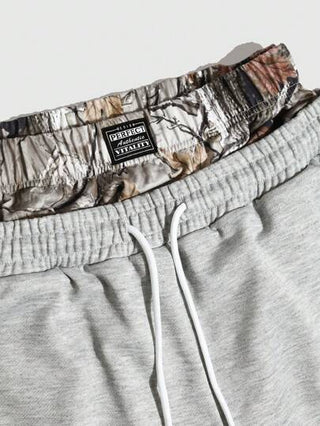 Manfinity Streetrush شورتات فضفاضة للرجال مزينة بطباعة حرفية مع خصر بسحاب