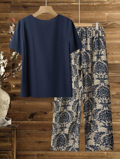 Lacomfia مجموعة من 2 قطعة للنساء، ملابس علوية بياقة مستديرة وأكمام قصيرة بلون أحادي، وبنطال مطبوع بطبعة نباتية للعطلات