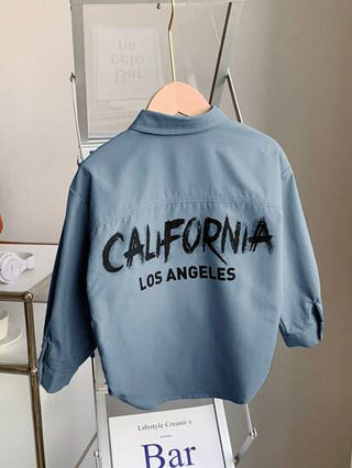 SHEIN قميص شبابي طويل الأكمام بياقة بولو، فضفاض محبوك بلون صلب، مطبوع عليه حروف وجرافيتي للأولاد، مناسب للتنقل والمدرسة واليومي والإجازات والرياضة في فصول الربيع والصيف والخريف والشتاء