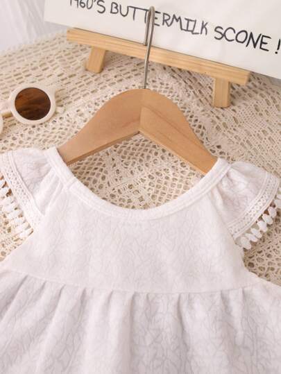 بذلة صيفية للبنات ذات طراز منعش وحلو، بنسيج كشكشة، بياقة دائرية بيضاء، بتصميم زخرفة شرابة، بشورت ذو ساق واسعة باللون البنفسجي، من خامة مريحة وقابلة للتنفس، مناسبة للبنات الصغيرات للارتداء اليومي العادي