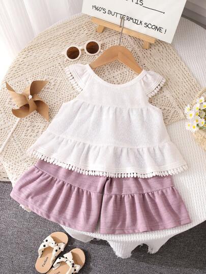 بذلة صيفية للبنات ذات طراز منعش وحلو، بنسيج كشكشة، بياقة دائرية بيضاء، بتصميم زخرفة شرابة، بشورت ذو ساق واسعة باللون البنفسجي، من خامة مريحة وقابلة للتنفس، مناسبة للبنات الصغيرات للارتداء اليومي العادي