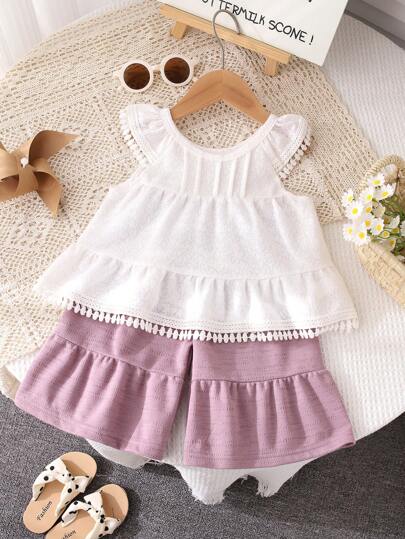 بذلة صيفية للبنات ذات طراز منعش وحلو، بنسيج كشكشة، بياقة دائرية بيضاء، بتصميم زخرفة شرابة، بشورت ذو ساق واسعة باللون البنفسجي، من خامة مريحة وقابلة للتنفس، مناسبة للبنات الصغيرات للارتداء اليومي العادي