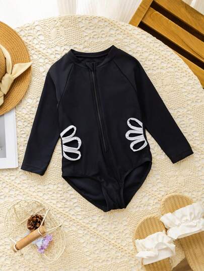 قطعة واحدة من ملابس السباحة وقطع تشكيل لفتاة صغيرة