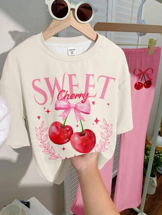 girls-sets طقم بنطلون قصير وتيشرت برسومات فتاة مراهقة مع فيونكة حلوة و طبعة الكرز، باللون الوردي، مناسب للصيف