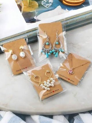 200 قطعة بطاقة تعبئة المجوهرات، بطاقات عرض قلادة أقراط المجوهرات، ورق كرتون تعبئة المجوهرات، بطاقات من ورق الكرافت السميك مصنوعة بحب وأكياس شفافة مجموعة ، مجموعة أكياس عرض المجوهرات، وسوم مقواة بنية عالية الجودة متعددة الاستخدامات، لشماعات الأقراط و تعبئة