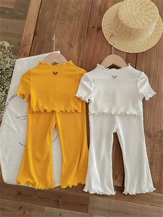 طقم مكون من 4 قطع لطفلة صغيرة يشمل بلوزة قصيرة بأكمام واسعة بشكل قلب محبوكة وسروال بأسلوب فضفاض مطبع بنقوشات مثقوبة