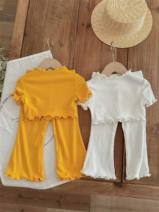 طقم مكون من 4 قطع لطفلة صغيرة يشمل بلوزة قصيرة بأكمام واسعة بشكل قلب محبوكة وسروال بأسلوب فضفاض مطبع بنقوشات مثقوبة