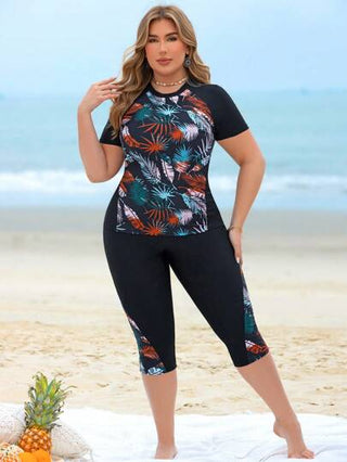 Swim Lushoire مجموعة ملابس سباحة غير رسمية لحمامات السباحة وشواطئ المنتجعات للمرأة ذات المقاسات الكبيرة، مكونة من توب كروب بدون أكمام مطبوع بتصميم رقعي مطبوع عشوائي بأوراق نباتية ممزوجة باللون الأسود وشورت سباحة طويل
