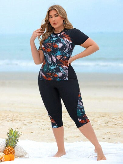 Swim Lushoire مجموعة ملابس سباحة غير رسمية لحمامات السباحة وشواطئ المنتجعات للمرأة ذات المقاسات الكبيرة، مكونة من توب كروب بدون أكمام مطبوع بتصميم رقعي مطبوع عشوائي بأوراق نباتية ممزوجة باللون الأسود وشورت سباحة طويل
