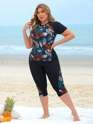 Swim Lushoire مجموعة ملابس سباحة غير رسمية لحمامات السباحة وشواطئ المنتجعات للمرأة ذات المقاسات الكبيرة، مكونة من توب كروب بدون أكمام مطبوع بتصميم رقعي مطبوع عشوائي بأوراق نباتية ممزوجة باللون الأسود وشورت سباحة طويل