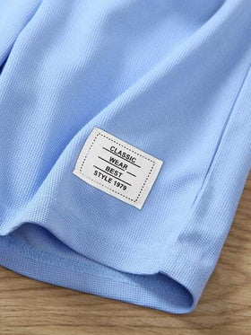 SHEIN Streecool Kids 2 قطعة مجموعة صيفية للأولاد، القميص كتان أزرق فاتح مزين بالنسيج المنسوج المحبوك، والشورت من القطن الأبيض مع ألوان متباينة، طراز رياضي مناسب للارتداء اليومي والإجازة والرياضة والمدرسة والعطلات