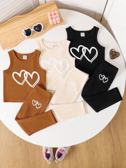 SHEIN بدلة رياضية كاجوال للأطفال البنات للربيع، تتكون من سترة كم بلا أكمام مع طبعات قلوب على نسيج مضلع وبنطلون فضفاض ذو خصر مطّاطي، 2 قطعة