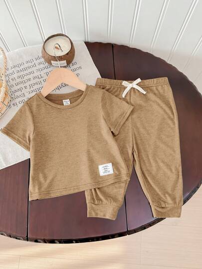 SHEIN طقم للطفل الصبي مكون من قطعتين بقماش ناعم مرن للغاية، مزين بأزرار، ملابس علوية ذات رقبة دائرية ناعمة وقصيرة الأكمام، وبنطال طويل بخصر مطاطي، مناسب للربيع والصيف والخروجات والعطلات والمدرسة والمنزل