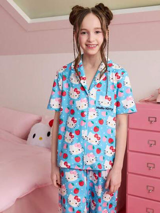 بيجاما HELLO KITTY AND FRIENDS |  مجموعة بيجاما مريحة من ملابس علوية ذو أكمام قصيرة وأزرار وسروال به جيب على الصدر، طباعة فراولة على خلفية زرقاء، طفولي ومناسب للفتيات المراهقات