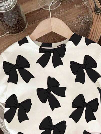 طقم ملابس للبنات الرضع من تي شيرت قصير الأكمام بياقة مستديرة مطبوع عليه الفيونكة ، وشورت أسيل مضفر قطعتين، ملابس منزلية بنقشة فيونكة سوداء ملابس بنات رضع كاجوال