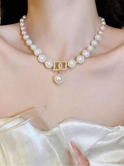 مجموعة مجوهرات للنساء مكونة من 3 قطع، تشمل قلادة مع حروف كبيرة ومغرفة لؤلؤية وأقراط، مناسبة للارتداء اليومي