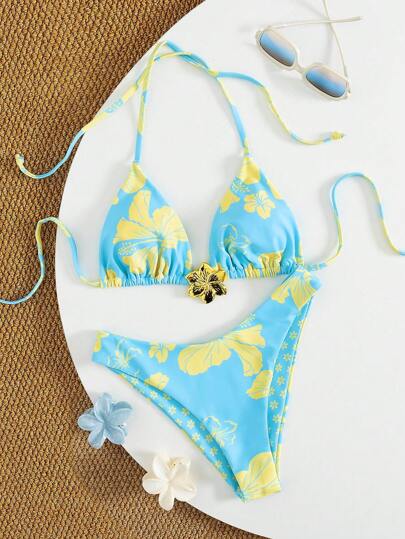 Swim Vcay مجموعة قطعتين للنساء بتصميم زهور المناطق الاستوائية وخطوط موسيقية بروح الاسترخاء والجاذبية، مع بذلة سباحة وزيّ معدني مزين بالزهور.