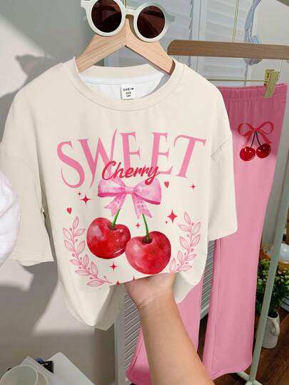 girls-sets طقم بنطلون قصير وتيشرت برسومات فتاة مراهقة مع فيونكة حلوة و طبعة الكرز، باللون الوردي، مناسب للصيف