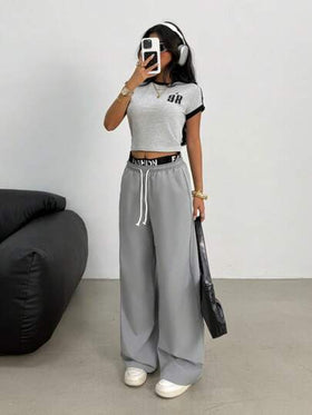 SHEIN بدلة رياضية للبنات المراهقات بطقم قميص أكمام قصيرة باللونين الأسود والرمادي بحواف مضادة وبنطلون فضفاض للساق ذو قطعتين بألوان عصرية