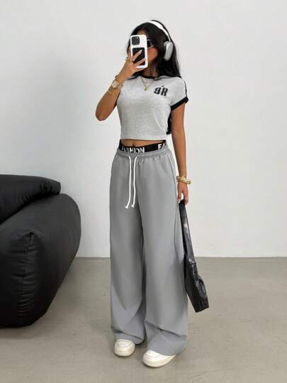 SHEIN بدلة رياضية للبنات المراهقات بطقم قميص أكمام قصيرة باللونين الأسود والرمادي بحواف مضادة وبنطلون فضفاض للساق ذو قطعتين بألوان عصرية