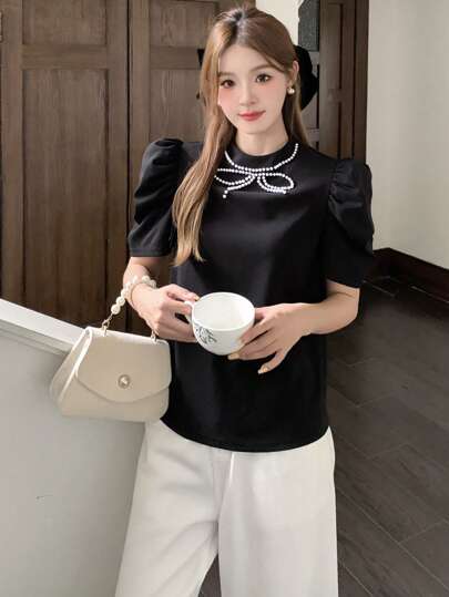 SHEIN تي شيرت أنيقة بتصميم عقدة الفراشة الرقبة المزخرف بالخرز للمراهقات، أكمام منفوخة منسوجة باللون الأسود