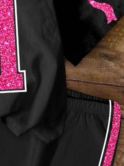SHEIN مجموعة قطعتين من التي شيرت والشورت المطبوعة بتصاميم مكتوبة للبنات الصغيرات، بأسلوب موضي عصري وشيك، مزينة بفيونكة، تصلح كإطلالة للمدرسة والسفر في فصل الصيف