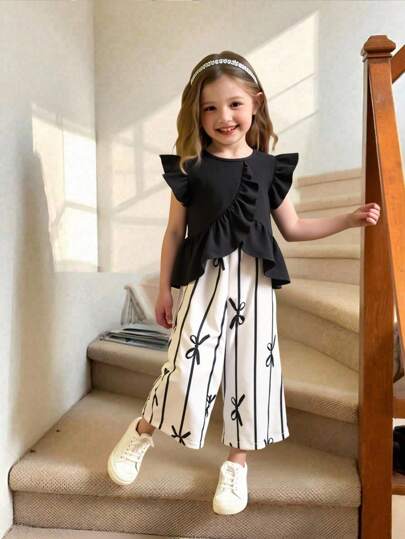 Elladie kids مجموعة بنطلون كاجوال للبنات الصغيرات بتصميم حاشية غير متماثلة وطباعة الفيونكة، مجموعة قطعتين للبنات الصغيرات، ملابس علوية علوية مكشكشة سوداء ومجموعة بنطلون مطبوع بالفيونكة للبنات الصغيرات، طقم أبيض وأسود للبنات الصغيرات، طقم صيفي للبنات الصغي