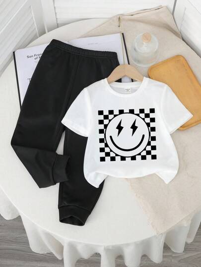 SHEIN طقم ملابس أطفال ولادي للخريف، جديد، كاجوال، مريح، أنيق، بطبعات غرافيتي مرسومة باليد، وجه كرتوني مبتسم، حرف إنجليزي، طراز Y2K، رقبة دائرية، أكمام قصيرة، بنطلون