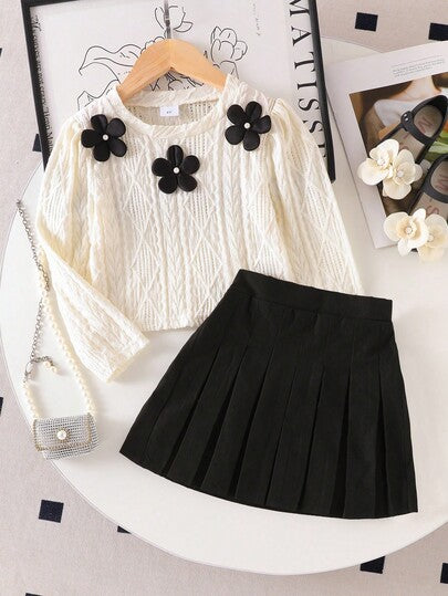 SHEIN Elladie kids طقم تي شيرت وتنورة صغيرة سوداء مريحة للفتيات الصغيرات، التي تتكون من بلوزة بياقة دائرية وأكمام طويلة بطبعات زهور بيضاء، مقترنة بتنورة سوداء مطوية