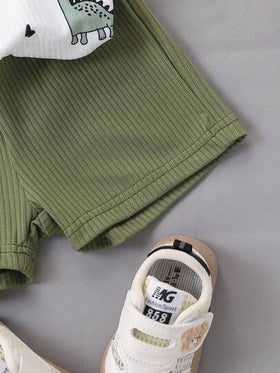 SHEIN طقم ملابس علوية بلا أكمام برقبة دائرية وشورت أخضر بطبعة ديناصور كرتونية للأطفال الصغار، طراز حيوي وجميل، مناسب للمغامرات الخارجية والارتداء المنزلي المريح وأوقات الحفلات الصيفية السعيدة