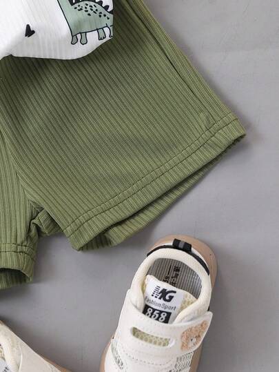 SHEIN طقم ملابس علوية بلا أكمام برقبة دائرية وشورت أخضر بطبعة ديناصور كرتونية للأطفال الصغار، طراز حيوي وجميل، مناسب للمغامرات الخارجية والارتداء المنزلي المريح وأوقات الحفلات الصيفية السعيدة
