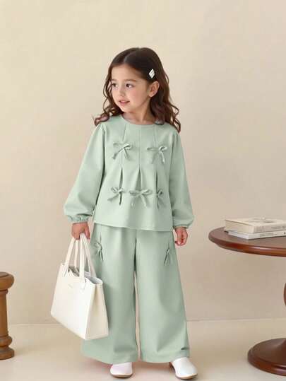 SHEIN Playful Pals مجموعة فتاة شابة أنيقة وحلوة تتكون من ملابس علوية مزينة بفيونكة + بنطلون ساق واسعة، للربيع/الخريف