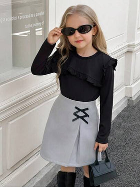 SHEIN Elladie kids طقم تي شيرت وتنورة للفتيات الصغيرات، التي تتكون من ملابس علوية سوداء طويلة الأكمام مزينة بالكشكشة مع تنورة مزينة بفيونكة وذات حافة مشقوقة، مناسب للخريف والشتاء