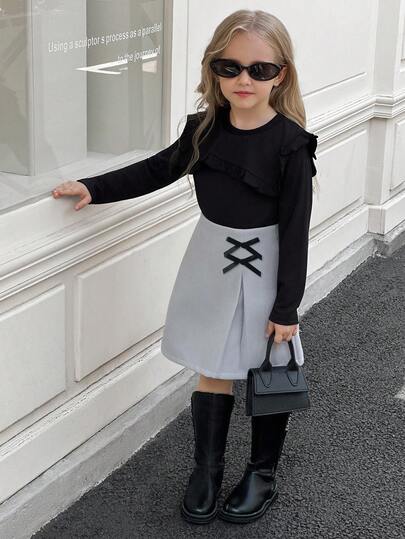 SHEIN Elladie kids طقم تي شيرت وتنورة للفتيات الصغيرات، التي تتكون من ملابس علوية سوداء طويلة الأكمام مزينة بالكشكشة مع تنورة مزينة بفيونكة وذات حافة مشقوقة، مناسب للخريف والشتاء