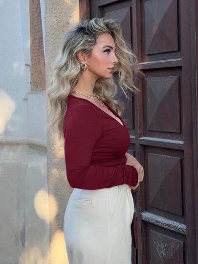 Jeta Ari قميص رياضي مقصر ضيق بأكمام طويلة وياقة على شكل حرف V، قطعة أساسية في خزانة ملابس المرأة ذات تصميم أنيق وعصري، مناسب لفصلي الربيع والخريف