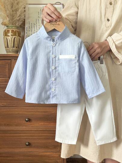 SHEIN Vintaside Kids طقم قطعتين للأطفال الصبيان يتميز بقميص أكمام طويلة ذو ياقة عالية بنقشة جاكارد أزرق وبنطلون أبيض ذو ساق مستقيمة، مناسب للربيع والخريف، ويصلح للخروجات المدرسية اليومية، حضور الحفلات، الاسترخاء في المنزل، والمناسبات الرسمية