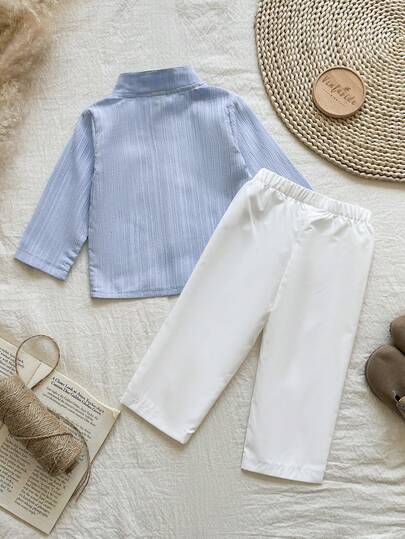 SHEIN Vintaside Kids طقم قطعتين للأطفال الصبيان يتميز بقميص أكمام طويلة ذو ياقة عالية بنقشة جاكارد أزرق وبنطلون أبيض ذو ساق مستقيمة، مناسب للربيع والخريف، ويصلح للخروجات المدرسية اليومية، حضور الحفلات، الاسترخاء في المنزل، والمناسبات الرسمية