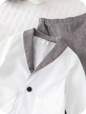 SHEIN مجموعة ملابس طفل ولد بأسلوب جنتلمان جذاب، تتكون من بليزر أبيض وبنطال رمادي كاجوال، مناسبة لحفلات عيد الميلاد والحفلات المسائية والأعراس وحفلات استقبال المولود الجديد وعيد الميلاد الأول، قطعتان