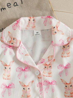 SHEIN مجموعة بيجاما مكونة من قطعتين للأطفال والفتيات الصغيرات، مطبوعة بأرنب وفيونكة ملونة من قماش قابل للتجعد، بفتحة أمامية وأكمام قصيرة، مريحة ومناسبة للفتيات الأنيقات والجميلات للاستخدام اليومي